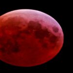 कन्या राशि में लगने वाले 3 मार्च फुल ब्लड मून 2026 के समय पृथ्वी की छाया में लाल रंग का चंद्रमा।