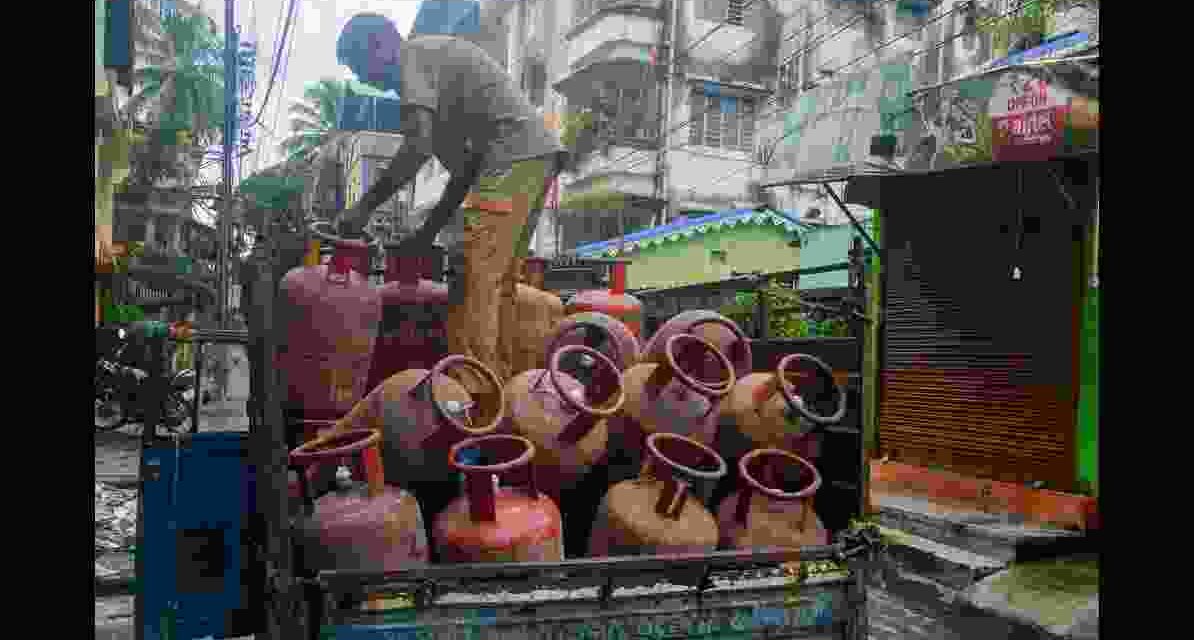 चित्र में एक भारतीय परिवार को एलपीजी सिलेंडर के साथ दिखाया गया है, जो दिल्ली मुफ्त LPG योजना के लाभार्थी का प्रतीक है।