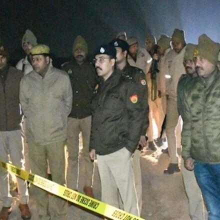 मेरठ शहर की सड़क पर फायरिंग के बाद पुलिस टीम जांच करती हुई और आसपास मौजूद लोग।