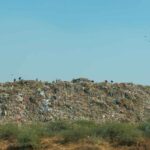 दिल्ली के गाजीपुर लैंडफिल और कचरे के अलगाव की प्रक्रिया को दर्शाती तस्वीर, जो नए ठोस कचरा नियम 2026 की आवश्यकता को समझाती है।