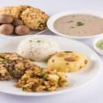 फल, दही, ड्राई फ्रूट्स और कम तेल में बने व्यंजनों से तैयार एक हेल्दी व्रत डाइट प्लेट।