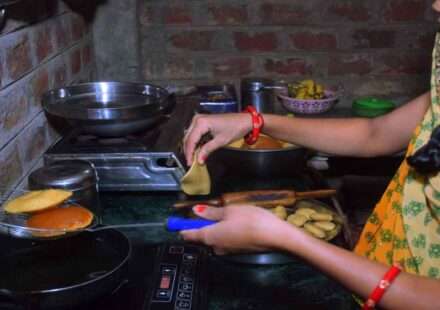 इंडक्शन चूल्हे पर खाना बनाती महिला, भारत में इंडक्शन कुकर की बढ़ती मांग