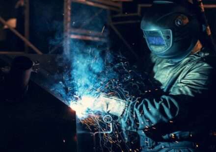 यह तस्वीर एक औद्योगिक क्षेत्र में काम कर रहे श्रमिकों को दिखाती है, जहां मशीनों और फैक्ट्री के बीच मेहनत करते मजदूर नजर आ रहे हैं। यह श्रमिक जीवन और मजदूरी से जुड़े हालात को दर्शाती है।