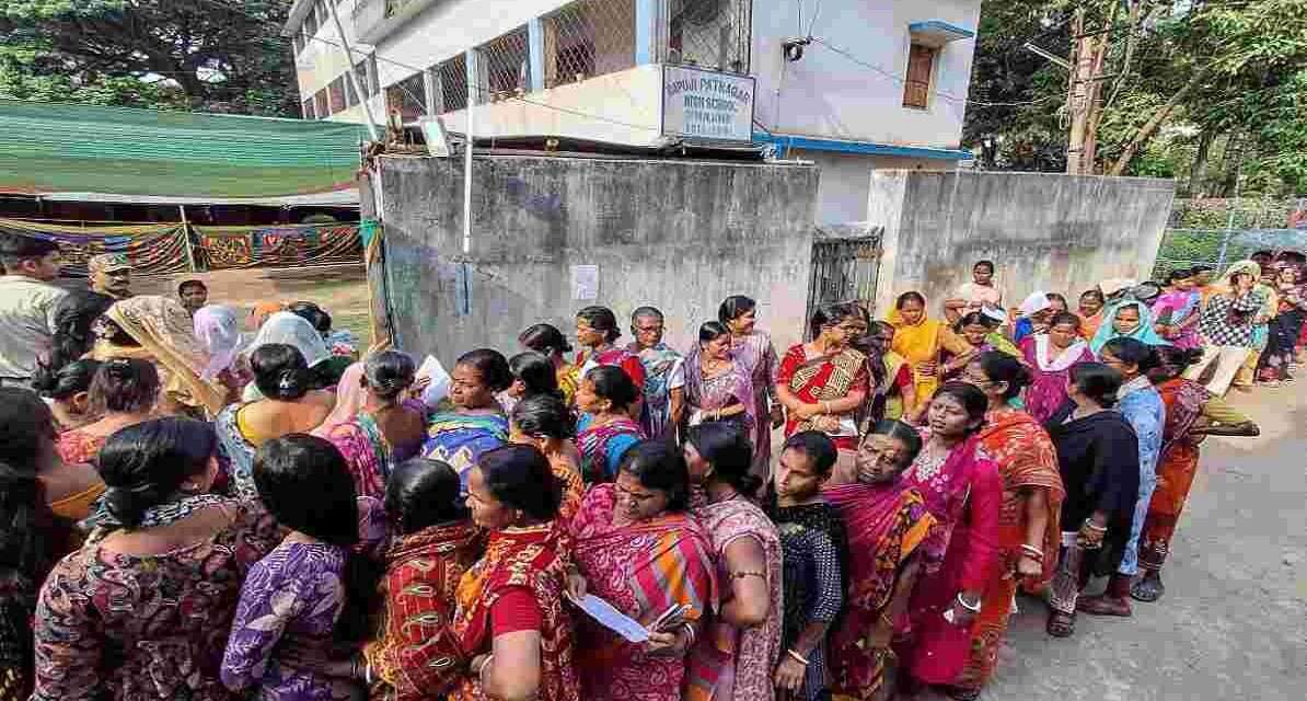 पोलिंग बूथ के बाहर बड़ी संख्या में खड़े मतदाता, जो बंगाल रिकॉर्ड मतदान को दर्शाते हैं