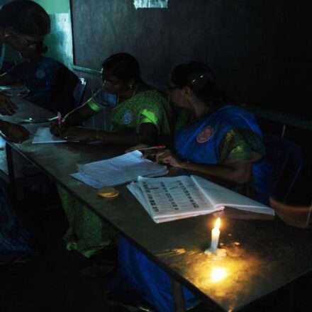 एक मतदान केंद्र जहां बिजली नहीं है और कम रोशनी में चुनाव की तैयारी की जा रही है