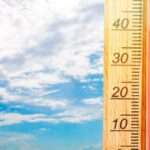 तेज धूप में सूखी जमीन और गर्म हवाओं के बीच चलती सड़क, जो हीटवेव की स्थिति को दर्शाती है।