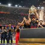 अहमदाबाद में आईपीएल 2026 फाइनल जीतने के बाद ट्रॉफी और 20 करोड़ रुपये की पुरस्कार राशि के साथ जश्न मनाती रॉयल चैलेंजर्स बेंगलुरु (RCB) टीम।